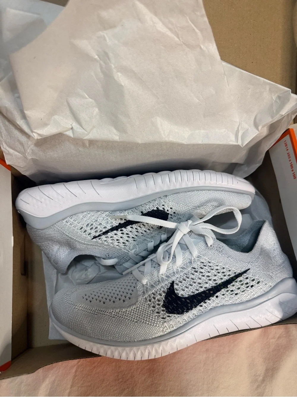 Nike White Flyknit Sneakers with Black Swoosh